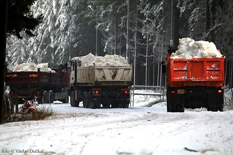 Nákladní vozidla rozvážejí sníh pro tratě. Nákladní vozidla rozvážejí sníh pro tratě.