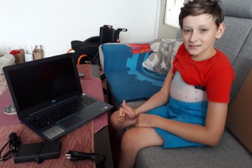 Foto: Jakub se raduje z nového notebooku, který mu pomůže při studiu