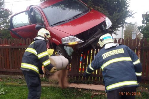 Foto: Auto přistálo ve Víchově na stromě a plotu rodinného domu  