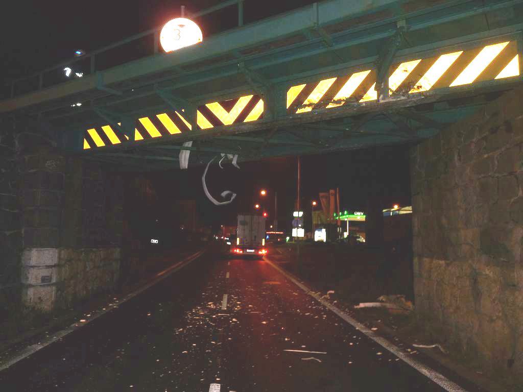 V Klatovech uvízl kamion pod viaduktem, ulámané části poničily auto