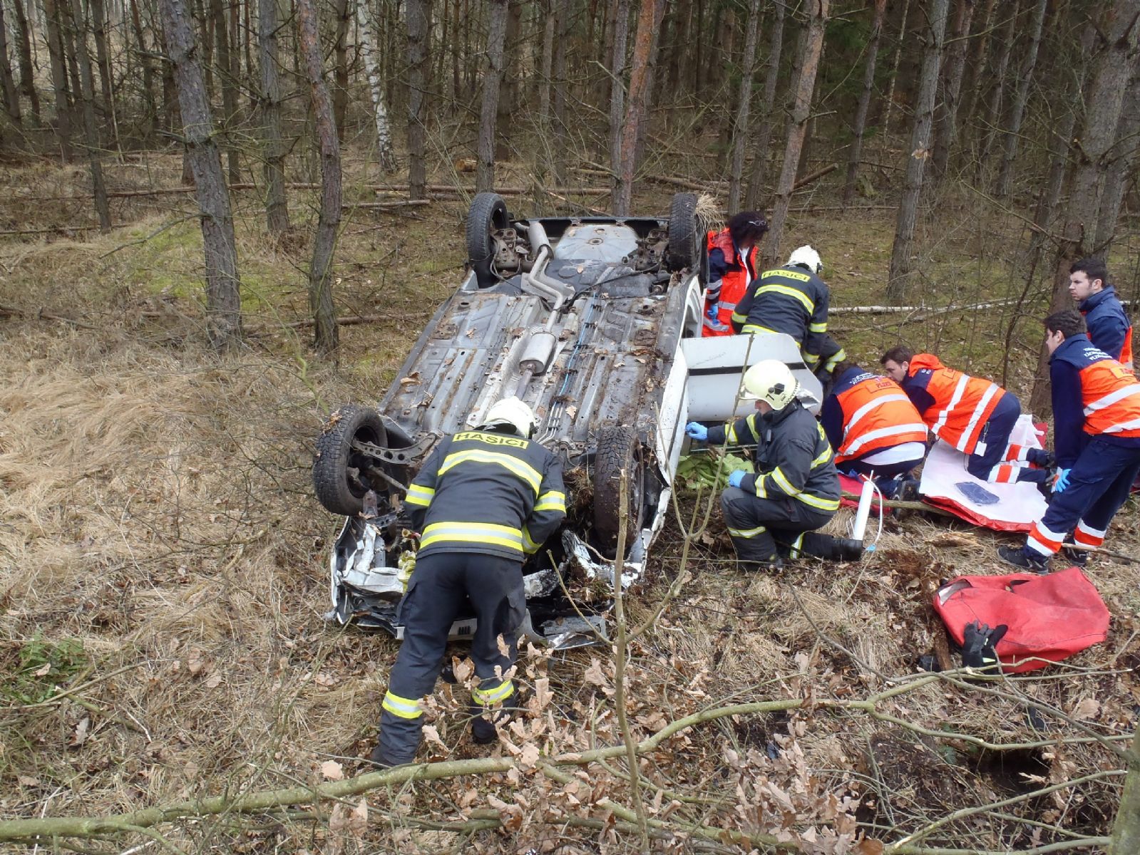 Za Zálužím skončilo auto v lese na střeše, řidička se zranila