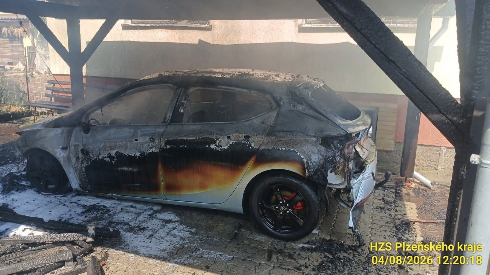 Požár u domu pohltil pergolu i auto. Hasiči evakuovali dva lidi a psa