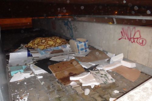 Foto: Bezdomovec si U Trati ustlal mezi odpadky